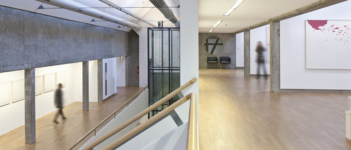 Moderne Galerie mit Betonwänden, Holzböden und minimalistischer Kunst. Menschen bewegen sich durch den Raum., © Stuttgart-Marketing GmbH Moderne Galerie mit Betonwänden, Holzböden und minimalistischer Kunst. Menschen bewegen sich durch den Raum., © Stuttgart-Marketing GmbH