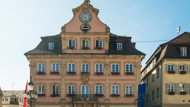 Das historische Rathaus von Schwäbisch Gmünd auf dem Marktplatz, mit einer Uhr im Giebel und blumengeschmückten Fenstern, bei sonnigem Wetter., © Stuttgart-Marketing GmbH, Sarah Schmid