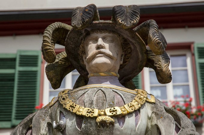 Eine Statue zeigt einen Mann mit einem Hut, aus dem Schlangen hervorkommen. Im Hintergrund sind grüne Fensterläden zu sehen., © Stadtverwaltung Weil der Stadt Eine Statue zeigt einen Mann mit einem Hut, aus dem Schlangen hervorkommen. Im Hintergrund sind grüne Fensterläden zu sehen., © Stadtverwaltung Weil der Stadt