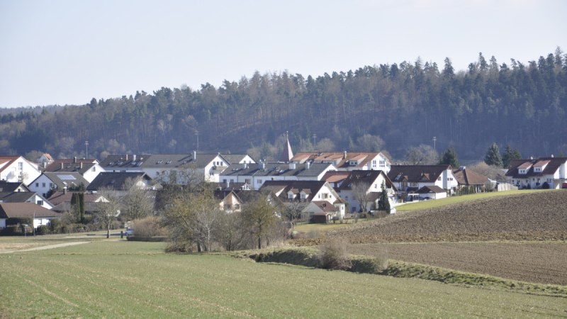 Ländliche Szene mit Häusern in Nufringen, umgeben von Feldern und einem Wald im Hintergrund unter klarem Himmel., © Natur.Nah. Schönbuch & Heckengäu Ländliche Szene mit Häusern in Nufringen, umgeben von Feldern und einem Wald im Hintergrund unter klarem Himmel., © Natur.Nah. Schönbuch & Heckengäu