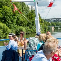 Menschen genie&szlig;en eine Bootsfahrt auf dem Neckar. Sie sitzen auf dem Deck, umgeben von gr&uuml;ner Landschaft und unterhalten sich fr&ouml;hlich., &copy; all copyrights are reserved by maks richter