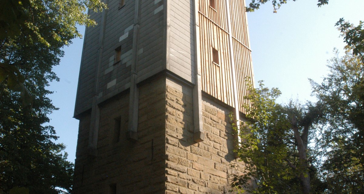 Ein hoher Turm aus Stein und Holz steht im Wald, umgeben von Bäumen. Der Himmel ist klar und sonnig., © TGMB Marbach Ein hoher Turm aus Stein und Holz steht im Wald, umgeben von Bäumen. Der Himmel ist klar und sonnig., © TGMB Marbach