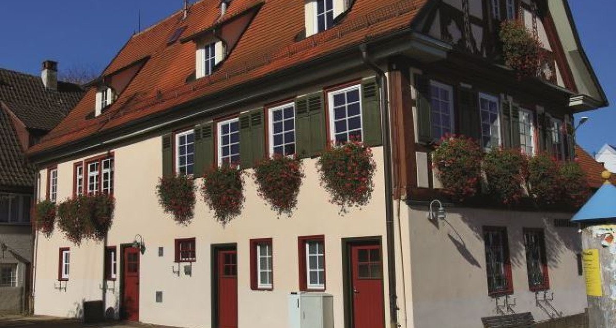 Historisches Rathaus in Ötlingen mit rotem Satteldach, Fachwerkdetails und Blumenkästen an den Fenstern. Sonniger Tag, blauer Himmel., © Stadt Kirchheim unter Teck Historisches Rathaus in Ötlingen mit rotem Satteldach, Fachwerkdetails und Blumenkästen an den Fenstern. Sonniger Tag, blauer Himmel., © Stadt Kirchheim unter Teck