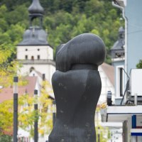Moderne Skulptur in einer städtischen Umgebung, im Hintergrund ein Kirchturm und grüne Bäume. Die Skulptur ist abstrakt und dunkel gefärbt., © Archiv Würth Moderne Skulptur in einer städtischen Umgebung, im Hintergrund ein Kirchturm und grüne Bäume. Die Skulptur ist abstrakt und dunkel gefärbt., © Archiv Würth