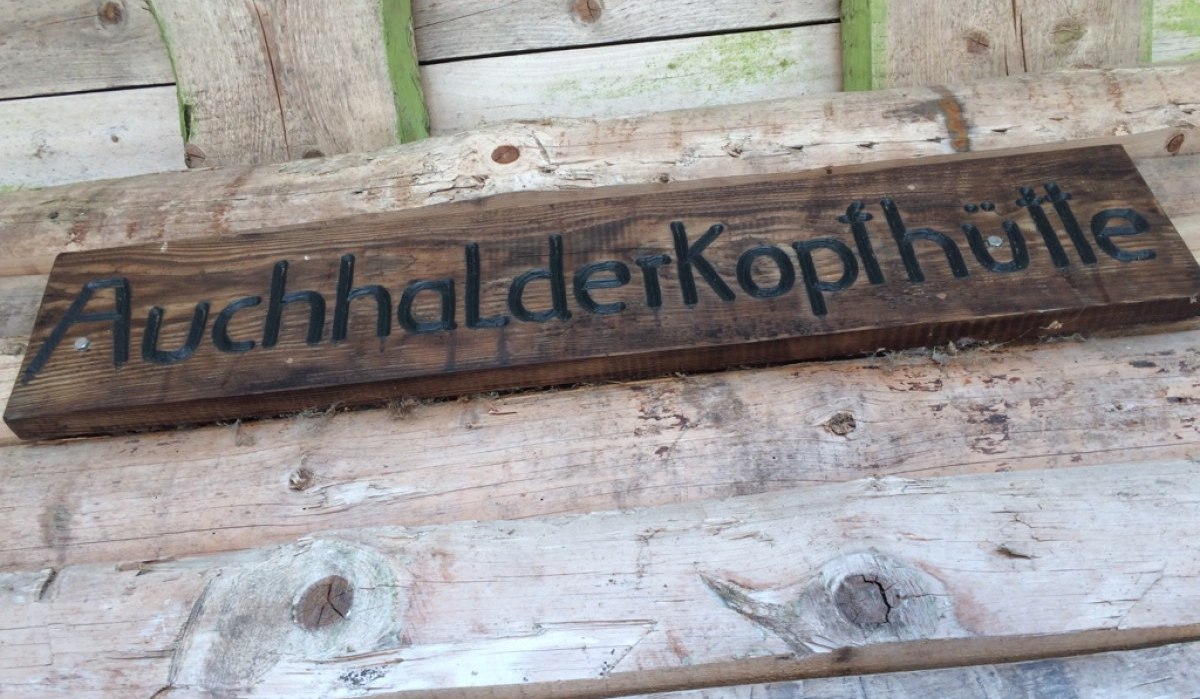 Holzschild mit der Aufschrift 'AuchhalderKopfhütte' an einer rustikalen Holzwand befestigt., © Nördlicher Schwarzwald Holzschild mit der Aufschrift 'AuchhalderKopfhütte' an einer rustikalen Holzwand befestigt., © Nördlicher Schwarzwald