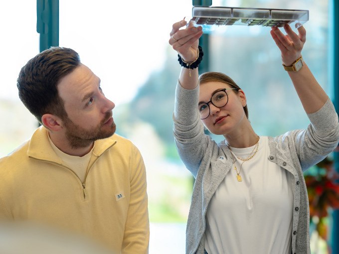 Zwei Personen betrachten eine Schokoladentafel. Eine Frau hält sie gegen das Licht, während ein Mann daneben steht. Hintergrund ist ein Fenster., © Alfred Ritter GmbH & Co. KG | Waldenbuch Zwei Personen betrachten eine Schokoladentafel. Eine Frau hält sie gegen das Licht, während ein Mann daneben steht. Hintergrund ist ein Fenster., © Alfred Ritter GmbH & Co. KG | Waldenbuch