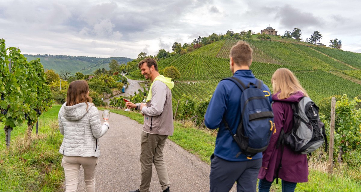 Menschen wandern auf einem Weinweg, halten Weingläser. Im Hintergrund Weinberge und die Grabkapelle auf einem Hügel., © Stuttgart-Marketing GmbH, Martina Denker Menschen wandern auf einem Weinweg, halten Weingläser. Im Hintergrund Weinberge und die Grabkapelle auf einem Hügel., © Stuttgart-Marketing GmbH, Martina Denker