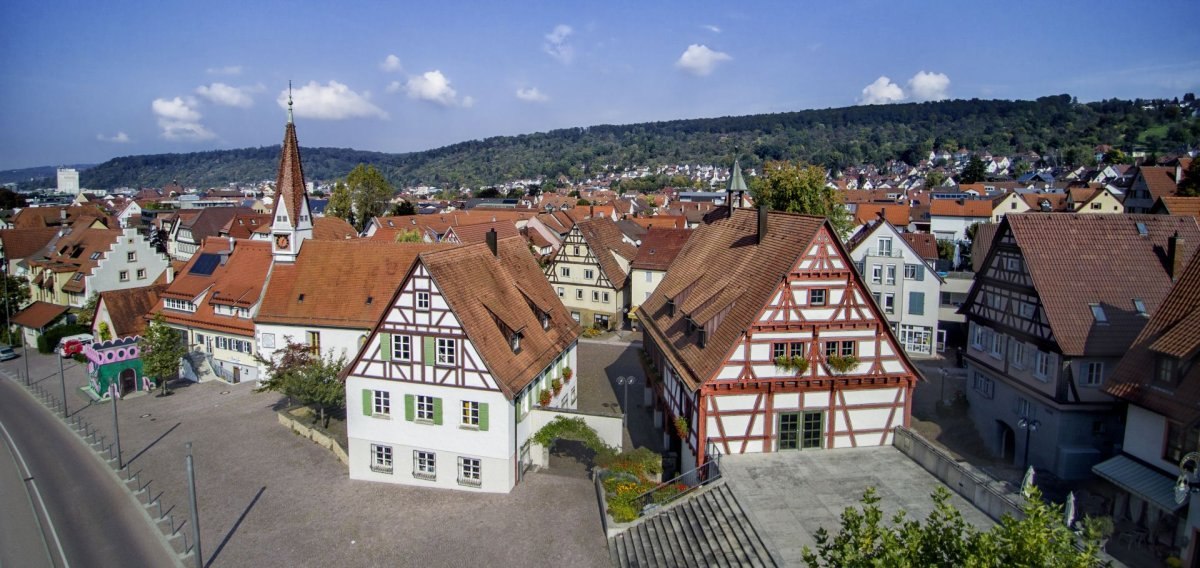 Panorama einer Altstadt mit Fachwerkh&auml;usern und einer Kirche. Im Hintergrund sind bewaldete H&uuml;gel zu sehen, der Himmel ist blau mit wenigen Wolken., &copy; Pressel-Fotodesign