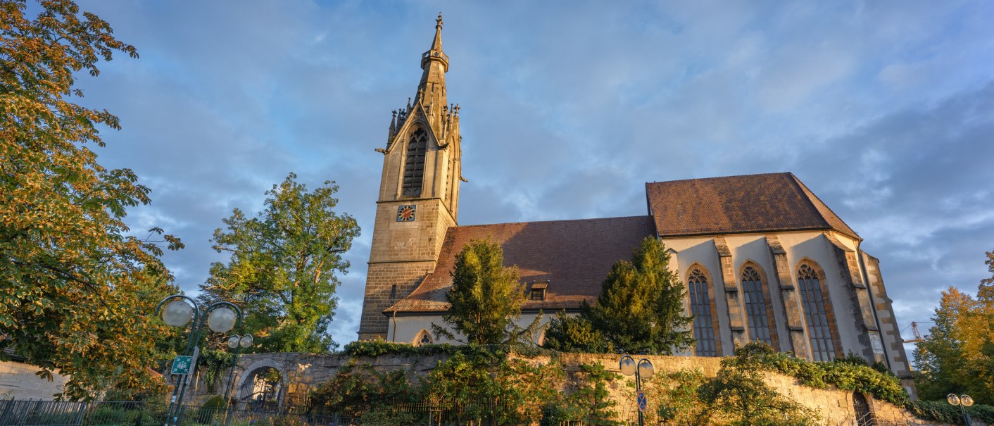 Die Stephanuskirche in Leinfelden-Echterdingen erstrahlt im warmen Herbstlicht, umgeben von buntem Laub und einem blauen Himmel., © SMG, Martina Denker Die Stephanuskirche in Leinfelden-Echterdingen erstrahlt im warmen Herbstlicht, umgeben von buntem Laub und einem blauen Himmel., © SMG, Martina Denker