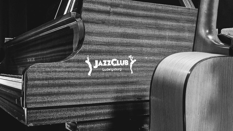 Ein Klavier und eine Gitarre im JazzClub Ludwigsburg, schwarz-wei&szlig; fotografiert. Der Schriftzug des Clubs ist auf dem Klavier zu sehen., &copy; Foto Ulrike Umbehr
