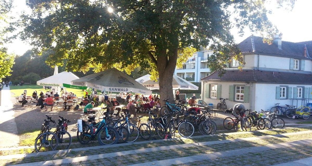 Ein Biergarten im Freien mit vielen Fahrr&auml;dern im Vordergrund. Menschen sitzen unter gro&szlig;en B&auml;umen und Sonnenschirmen, genie&szlig;en das Wetter., &copy; Kulturamt Plochingen