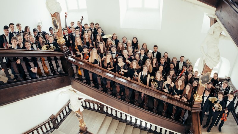 Das Landesjugendorchester Baden-W&uuml;rttemberg posiert auf einer Treppe in einem historischen Geb&auml;ude. Die Musiker halten ihre Instrumente., &copy; Kultur- und Sportamt Stadt Bietigheim-Bissingen