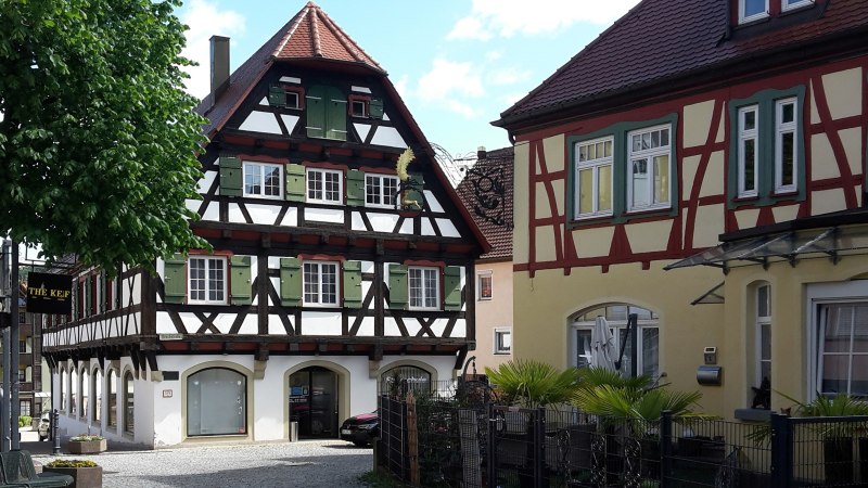 zwei Fachwerkh&auml;user - das Linke mit dunklem Fachwerk und wei&szlig;en Gefachen mit gr&uuml;nen Fensterl&auml;den, das Rechte in gelb mit r&ouml;tlichen Holzbalken, &copy; Petra Natzkowski
