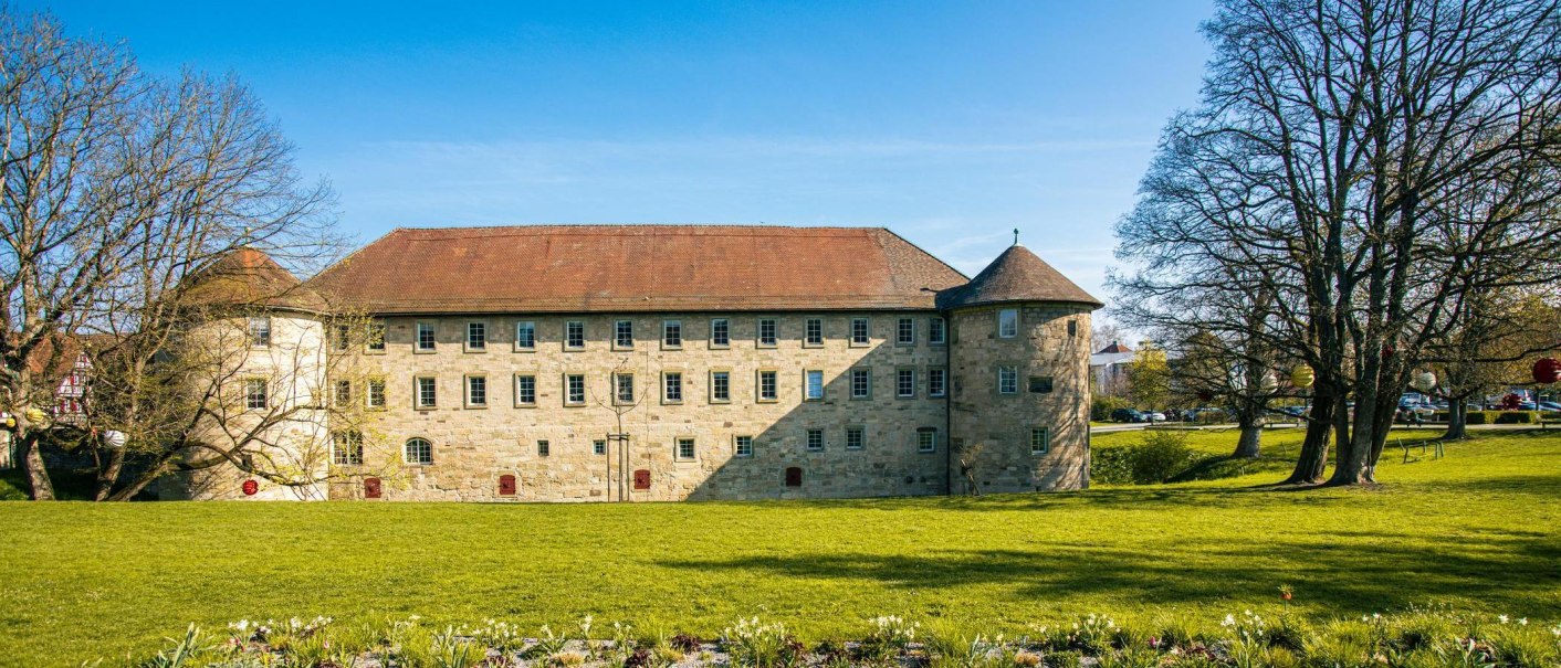 Das Burgschloss in Schorndorf, umgeben von einer grünen Wiese und Bäumen, unter einem klaren blauen Himmel., © Stuttgart-Marketing GmbH, Sarah Schmid Das Burgschloss in Schorndorf, umgeben von einer grünen Wiese und Bäumen, unter einem klaren blauen Himmel., © Stuttgart-Marketing GmbH, Sarah Schmid