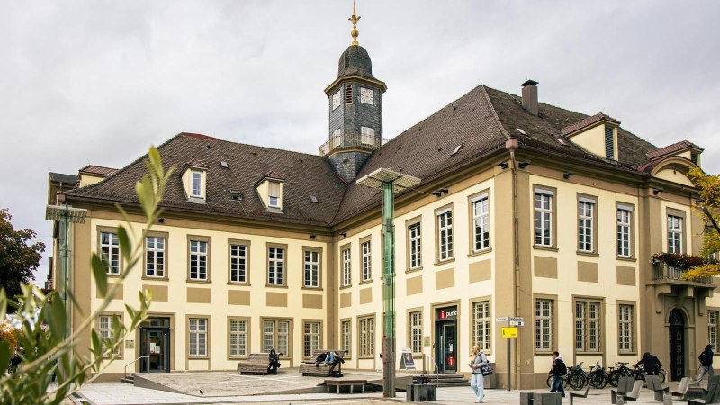 Das historische Rathaus von Göppingen am Marktplatz, umgeben von Bäumen und Menschen. Der Uhrturm ragt über das Gebäude hinaus., © SMG, Sarah Schmid Das historische Rathaus von Göppingen am Marktplatz, umgeben von Bäumen und Menschen. Der Uhrturm ragt über das Gebäude hinaus., © SMG, Sarah Schmid