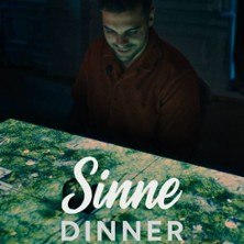 Ein Mann sitzt vor einem Tisch mit projizierten Bildern. Der Text 'Sinne Dinner' ist sichtbar., © links im Bild Ein Mann sitzt vor einem Tisch mit projizierten Bildern. Der Text 'Sinne Dinner' ist sichtbar., © links im Bild