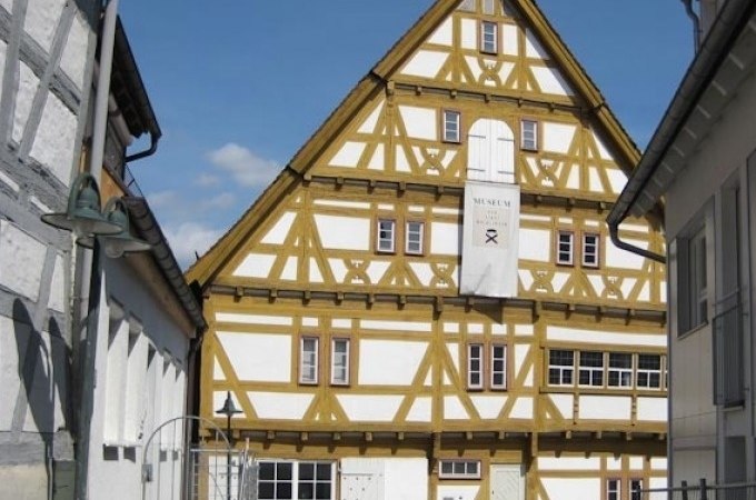 Fachwerkhaus in Waiblingen mit Barockelementen, weiß und gelb gestrichen. Ein Schild weist auf ein Museum hin. Blauer Himmel im Hintergrund., © WTM GmbH Waiblingen Fachwerkhaus in Waiblingen mit Barockelementen, weiß und gelb gestrichen. Ein Schild weist auf ein Museum hin. Blauer Himmel im Hintergrund., © WTM GmbH Waiblingen