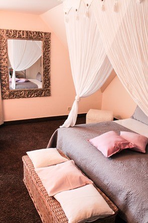 Elegantes Schlafzimmer mit Himmelbett, dekorativen Kissen und großem Spiegel an der Wand. Der Raum wirkt luxuriös und einladend., © Hotel Princess