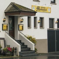 Eingang des Gasthauses Monbachtal mit Treppe, Blumendekoration und beleuchteten Laternen an der weißen Fassade., © Stuttgart Marketing GmbH, Sarah Schmid Eingang des Gasthauses Monbachtal mit Treppe, Blumendekoration und beleuchteten Laternen an der weißen Fassade., © Stuttgart Marketing GmbH, Sarah Schmid