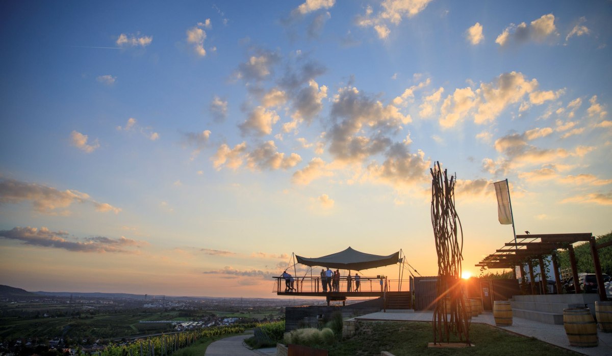 Sonnenuntergang über einer Terrasse mit Aussichtspunkt. Menschen genießen die Aussicht auf Weinberge und die Landschaft im Remstal., © Stoppel Sonnenuntergang über einer Terrasse mit Aussichtspunkt. Menschen genießen die Aussicht auf Weinberge und die Landschaft im Remstal., © Stoppel