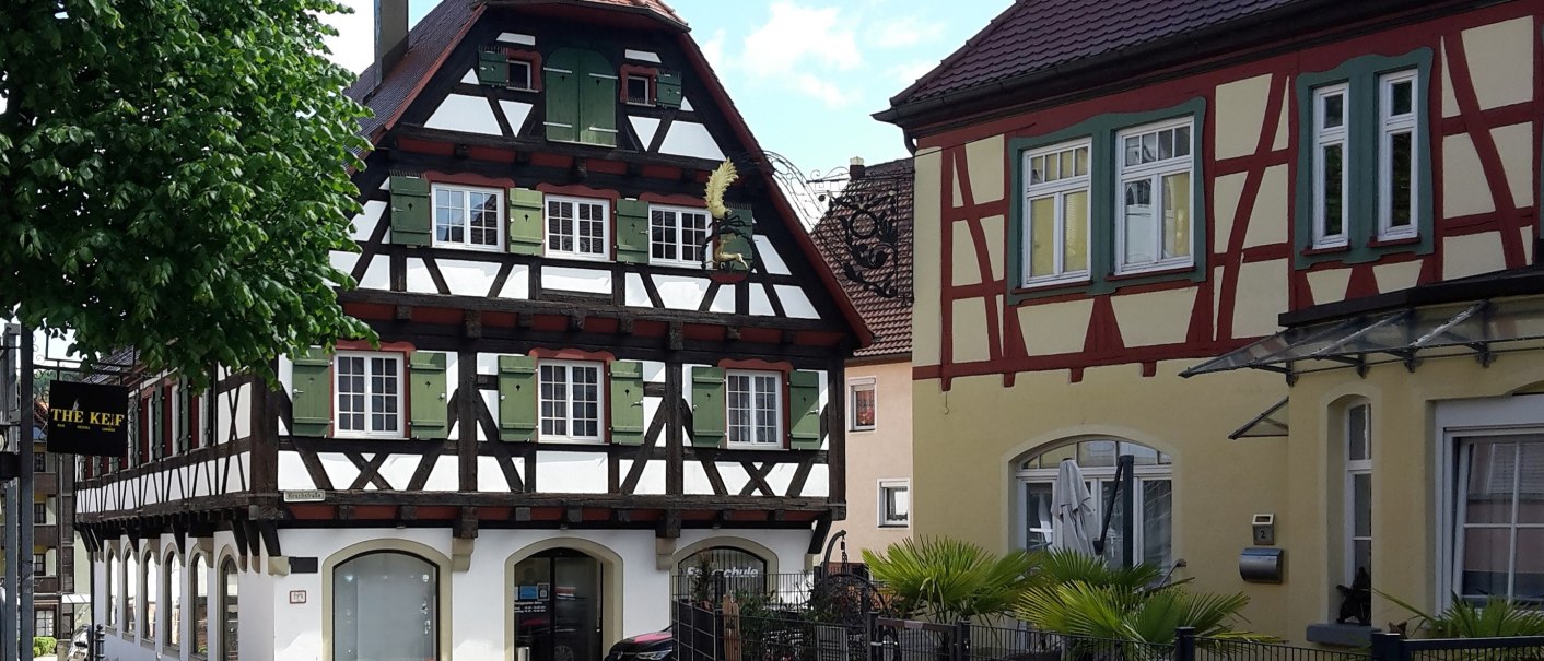 zwei Fachwerkhäuser - das Linke mit dunklem Fachwerk und weißen Gefachen mit grünen Fensterläden, das Rechte in gelb mit rötlichen Holzbalken, © Petra Natzkowski zwei Fachwerkhäuser - das Linke mit dunklem Fachwerk und weißen Gefachen mit grünen Fensterläden, das Rechte in gelb mit rötlichen Holzbalken, © Petra Natzkowski