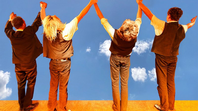 Vier Personen stehen auf einer Bühne, halten sich die Hände und blicken in den blauen Himmel mit Wolken., © Stadtverwaltung Schorndorf