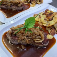 Zwei Teller mit Zwiebelrostbraten und knusprigen Bratkartoffeln, garniert mit frischen Kräutern. Ein traditionelles schwäbisches Gericht., © SchwäbischesGasthaus Zwei Teller mit Zwiebelrostbraten und knusprigen Bratkartoffeln, garniert mit frischen Kräutern. Ein traditionelles schwäbisches Gericht., © SchwäbischesGasthaus