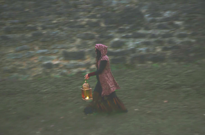 Eine Person in einem Kapuzenmantel trägt eine leuchtende Laterne vor einer alten Steinmauer entlang., © Esslinger Stadtmarketing &amp; Tourismus GmbH