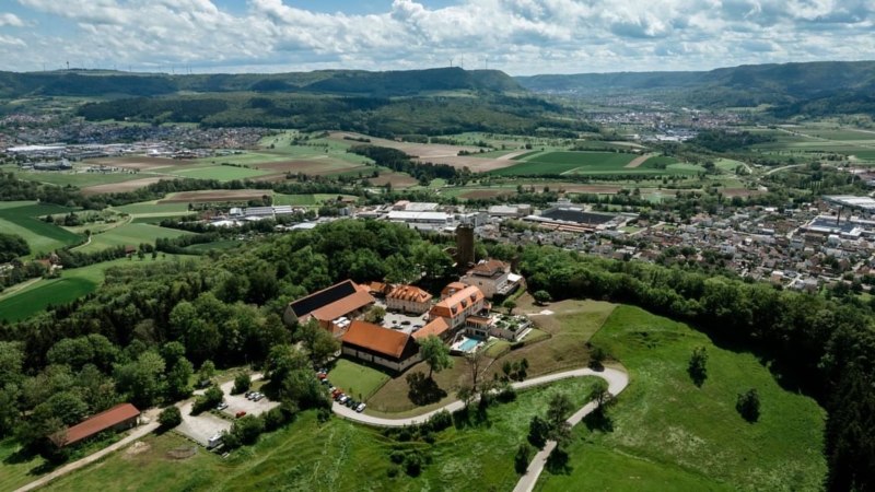 Luftaufnahme der Burg Staufeneck, umgeben von grünen Feldern und Wäldern, mit Blick auf eine Stadt im Hintergrund., © Christian Prerauer