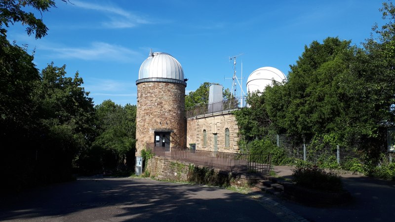 Eine Sternwarte mit runder Kuppel und Eingang, umgeben von B&auml;umen und blauem Himmel., &copy; SMG