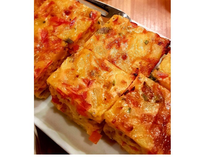Nahaufnahme von geschnittenen Tortilla-Stücken mit Paprika auf einem weißen Teller., © Kultweine-Kochwelten-Kunstücke - Kochschule Sonja Lenz Nahaufnahme von geschnittenen Tortilla-Stücken mit Paprika auf einem weißen Teller., © Kultweine-Kochwelten-Kunstücke - Kochschule Sonja Lenz