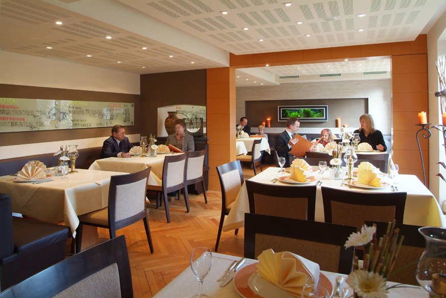 Elegantes Restaurant mit gedeckten Tischen und Gästen. Warme Beleuchtung, stilvolle Dekoration und entspannte Atmosphäre., © Römerhof Hotelbetriebs GmbH