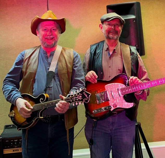 Zwei Musiker posieren mit Mandoline und E-Gitarre. Der linke tr&auml;gt einen Cowboyhut, der rechte eine Schieberm&uuml;tze. Sie stehen vor einem Lautsprecher., &copy; Thomas Eisele