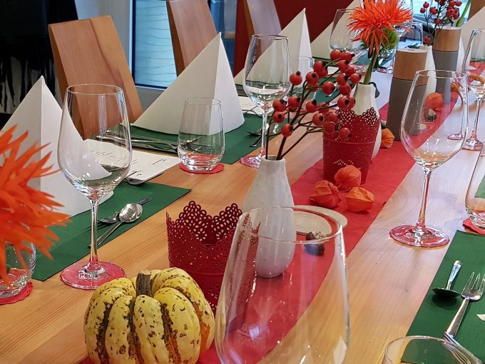 Festlich gedeckter Tisch mit Gläsern, weißen Servietten und herbstlicher Dekoration wie Kürbissen und roten Beeren., © Kultweine-Kochwelten-Kunstücke - Kochschule Sonja Lenz Festlich gedeckter Tisch mit Gläsern, weißen Servietten und herbstlicher Dekoration wie Kürbissen und roten Beeren., © Kultweine-Kochwelten-Kunstücke - Kochschule Sonja Lenz