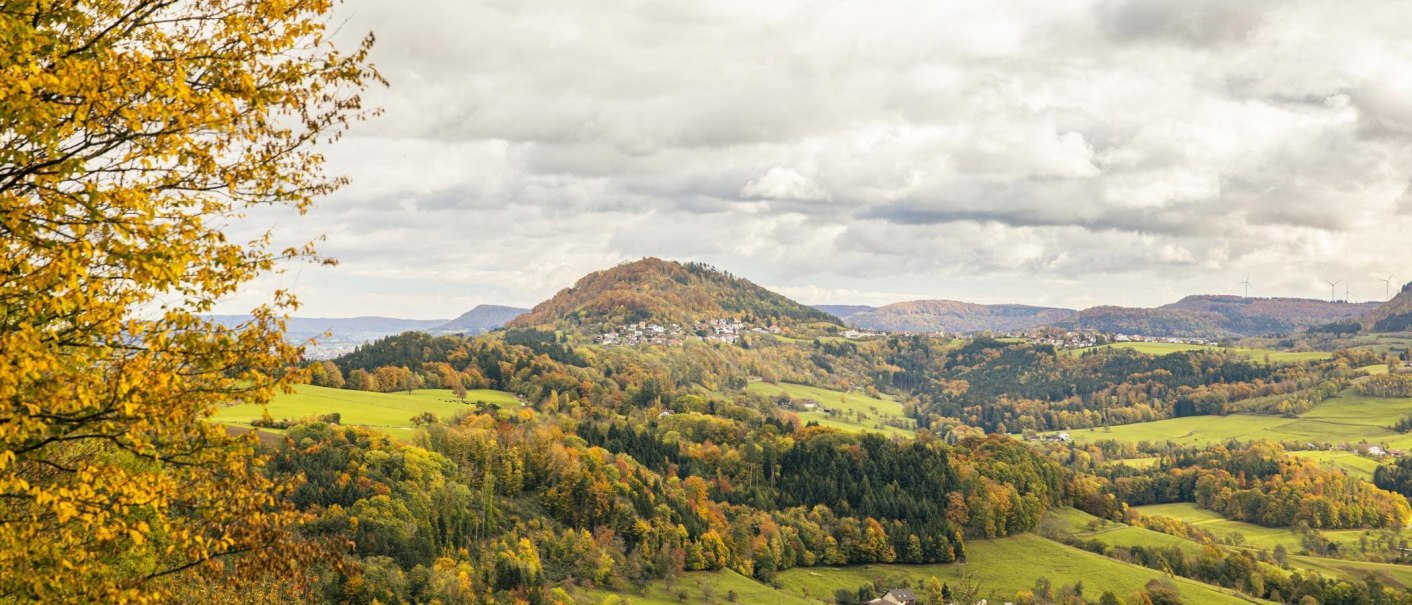 Herbstliche Landschaft mit Blick auf den Hohenstaufen bei Göppingen. Bunte Bäume und ein bewölkter Himmel prägen die Szenerie., © SMG, Sarah Schmid Herbstliche Landschaft mit Blick auf den Hohenstaufen bei Göppingen. Bunte Bäume und ein bewölkter Himmel prägen die Szenerie., © SMG, Sarah Schmid