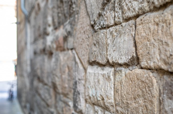 Nahaufnahme einer alten Steinmauer mit groben, rechteckigen Steinen. Die Struktur und Maserung der Steine sind deutlich sichtbar., © Touristik und Marketing GmbH