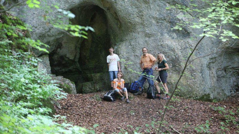 Eine Familie macht vor der Wassersteinhöhle eine Pause, © Bad Urach Tourismus Eine Familie macht vor der Wassersteinhöhle eine Pause, © Bad Urach Tourismus