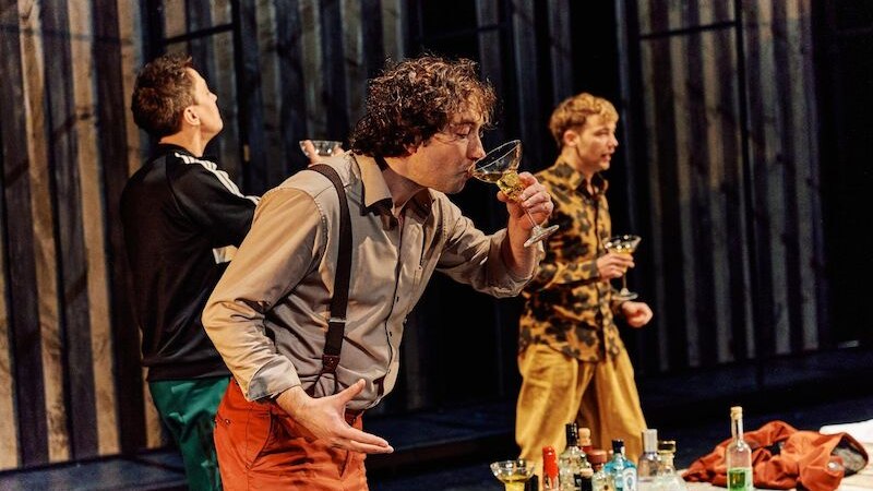 Drei Männer auf einer Bühne trinken Cocktails. Ein Tisch mit verschiedenen Flaschen steht im Vordergrund. Die Szene wirkt lebhaft und dynamisch., © Kulturbüro Schwäbisch Gmünd Drei Männer auf einer Bühne trinken Cocktails. Ein Tisch mit verschiedenen Flaschen steht im Vordergrund. Die Szene wirkt lebhaft und dynamisch., © Kulturbüro Schwäbisch Gmünd