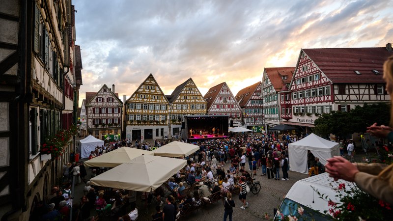 Stra&szlig;enmusikfestival in Herrenberg: Menschenmenge vor einer B&uuml;hne, umgeben von historischen Fachwerkh&auml;usern bei Sonnenuntergang., &copy; Andreas Sporn
