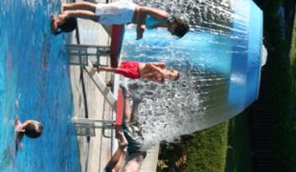 Menschen genießen das Schwimmbad im Badezentrum Sindelfingen, stehen unter einem großen Wasserpilz. Sommerliche Atmosphäre mit viel Wasseraktivität., © Sindelfingen - Stuttgart-Marketing GmbH