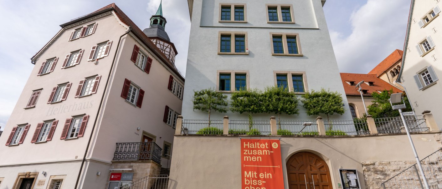 Das Bandhaus Theater in Backnang mit benachbarten historischen Gebäuden. Ein Plakat fordert zur Einhaltung von Abstand auf. Der Himmel ist bewölkt., © Stuttgart Marketing GmbH, Fotografin Martina Denker