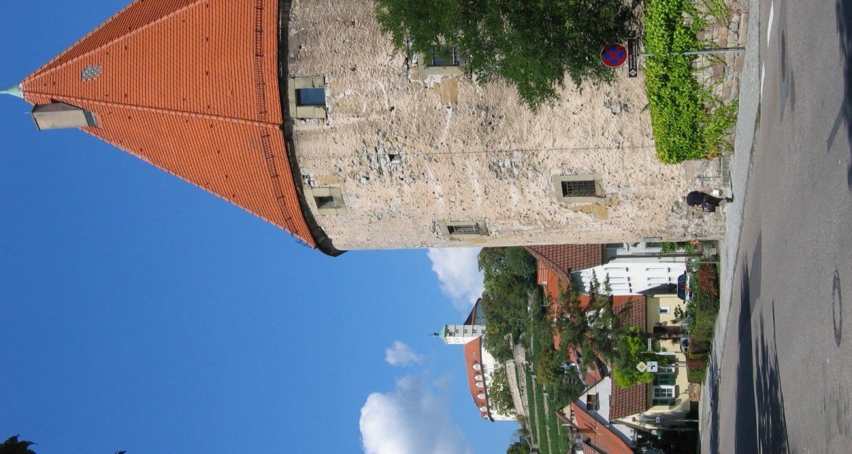 Mittelalterlicher Turm mit rotem Dach, umgeben von Bäumen und Häusern. Blauer Himmel im Hintergrund., © Land der 1000 Hügel - Kraichgau-Stromberg Mittelalterlicher Turm mit rotem Dach, umgeben von Bäumen und Häusern. Blauer Himmel im Hintergrund., © Land der 1000 Hügel - Kraichgau-Stromberg