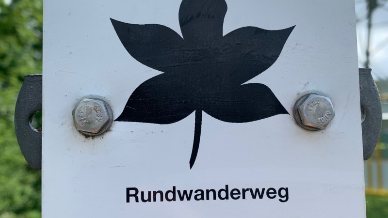 Wegweiser für den Rundwanderweg in Remseck am Neckar. Ein Ahornblatt-Symbol und die Zahl 1 sind abgebildet.
