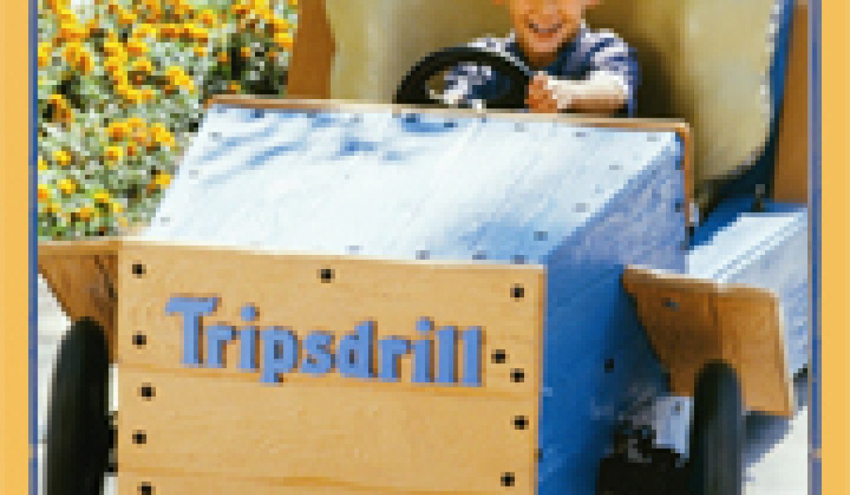 Ein Kind in einem Holzauto mit 'Tripsdrill'-Schriftzug, umgeben von bunten Blumen. Text: 'Bahn frei ...', © Land der 1000 Hügel - Kraichgau-Stromberg