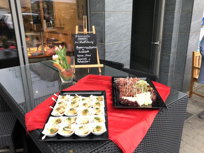 Ein Tisch mit Speisen auf schwarzen Platten, dekoriert mit roten T&uuml;chern und Blumen. Eine Tafel beschreibt die angebotenen Leckereien., &copy; Eigenbetrieb Tourismus und Citymanagement Schorndorf