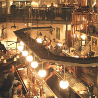 Belebtes Restaurant mit Braukesseln, Gästen an Tischen und einer Bar. Industrielles Design mit warmem Licht und moderner Einrichtung., © Kesselhaus, Schorndorf
