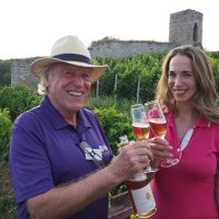 Zwei Personen sto&szlig;en mit Sektgl&auml;sern in einem Weinberg an. Im Hintergrund ist eine alte Steinruine zu sehen., &copy; &copy; Tourismus & Events Ludwigsburg