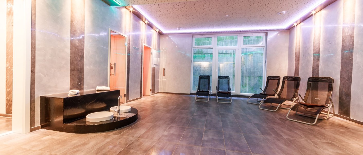 Moderner Saunaraum mit Liegestühlen, Fußbecken und stilvoller Beleuchtung. Große Fensterfront und elegante Wandgestaltung., © Plaza Residence Stuttgart-Ditzingen Moderner Saunaraum mit Liegestühlen, Fußbecken und stilvoller Beleuchtung. Große Fensterfront und elegante Wandgestaltung., © Plaza Residence Stuttgart-Ditzingen