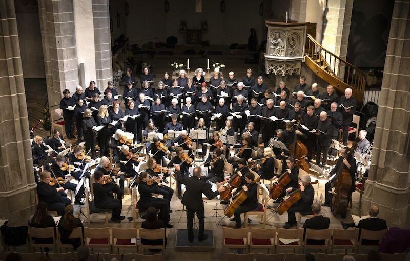 Ein Orchester und Chor führen in einer Kirche ein klassisches Konzert auf. Der Dirigent steht vor den Musikern, die in einem Halbkreis sitzen., © Evangelische Kirchengemeinde Waiblingen