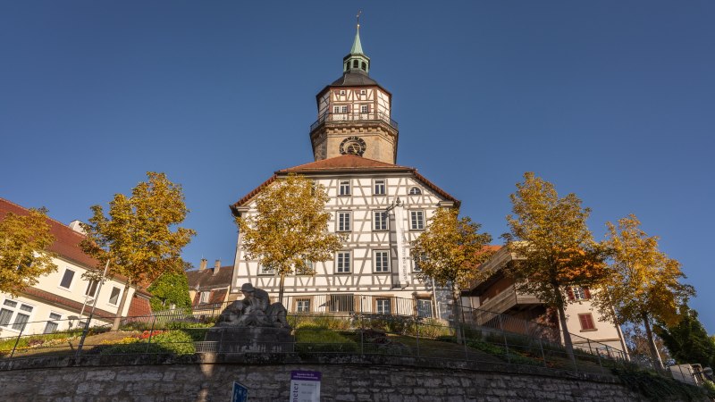 Der Backnanger Stadtturm mit Fachwerkfassade, umgeben von herbstlichen Bäumen und blauen Himmel., © Stuttgart-Marketing GmbH, Martina Denker Der Backnanger Stadtturm mit Fachwerkfassade, umgeben von herbstlichen Bäumen und blauen Himmel., © Stuttgart-Marketing GmbH, Martina Denker